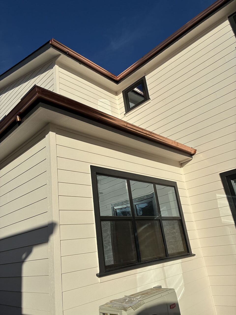 Stepped massing with copper gutters wrapping multiple elevations and inside corners