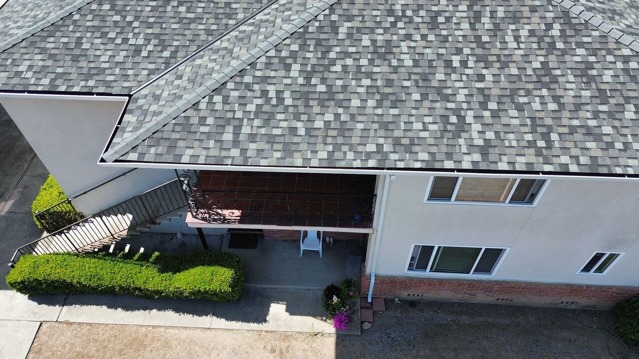 Aerial view of new Landmark shingle roof, new aluminum gutters, and downspout routed to grade