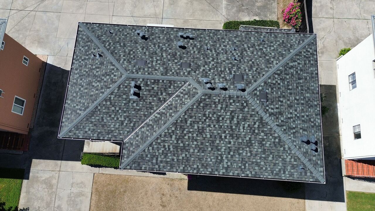 Full aerial footprint of the home with new Landmark shingle roof, neighboring properties visible on either side