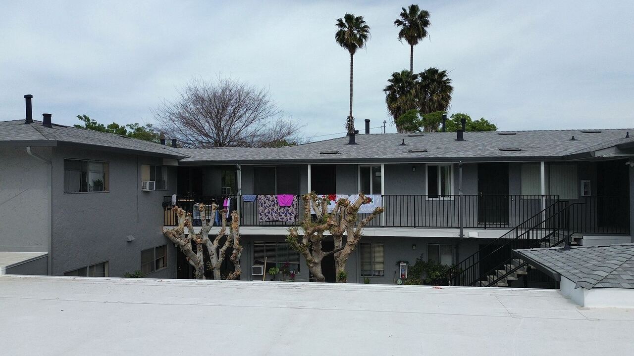 Ground-level view across the new single-ply carport deck looking at the apartment building façade
