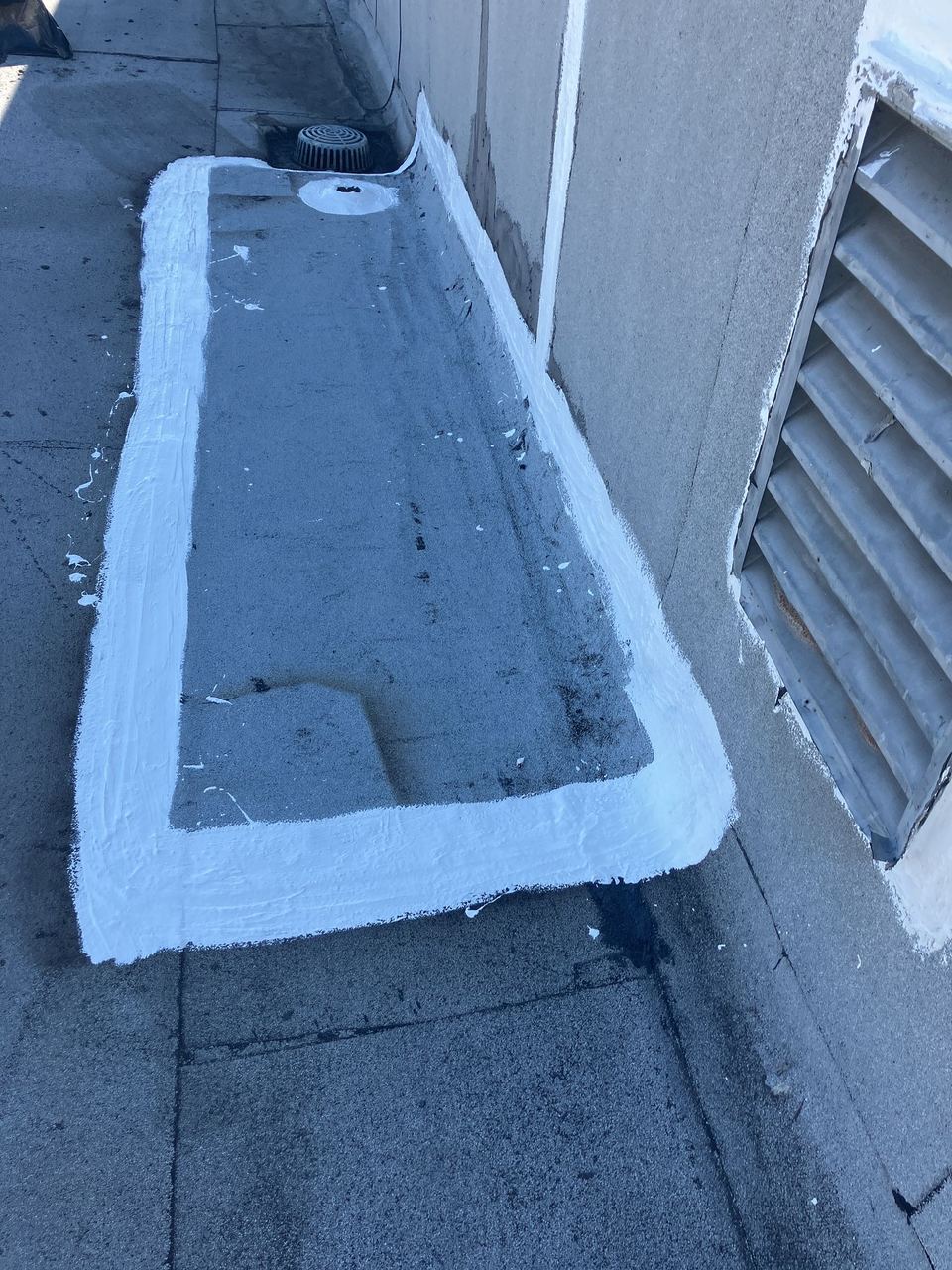 Drain flashing coated and sealed during commercial maintenance