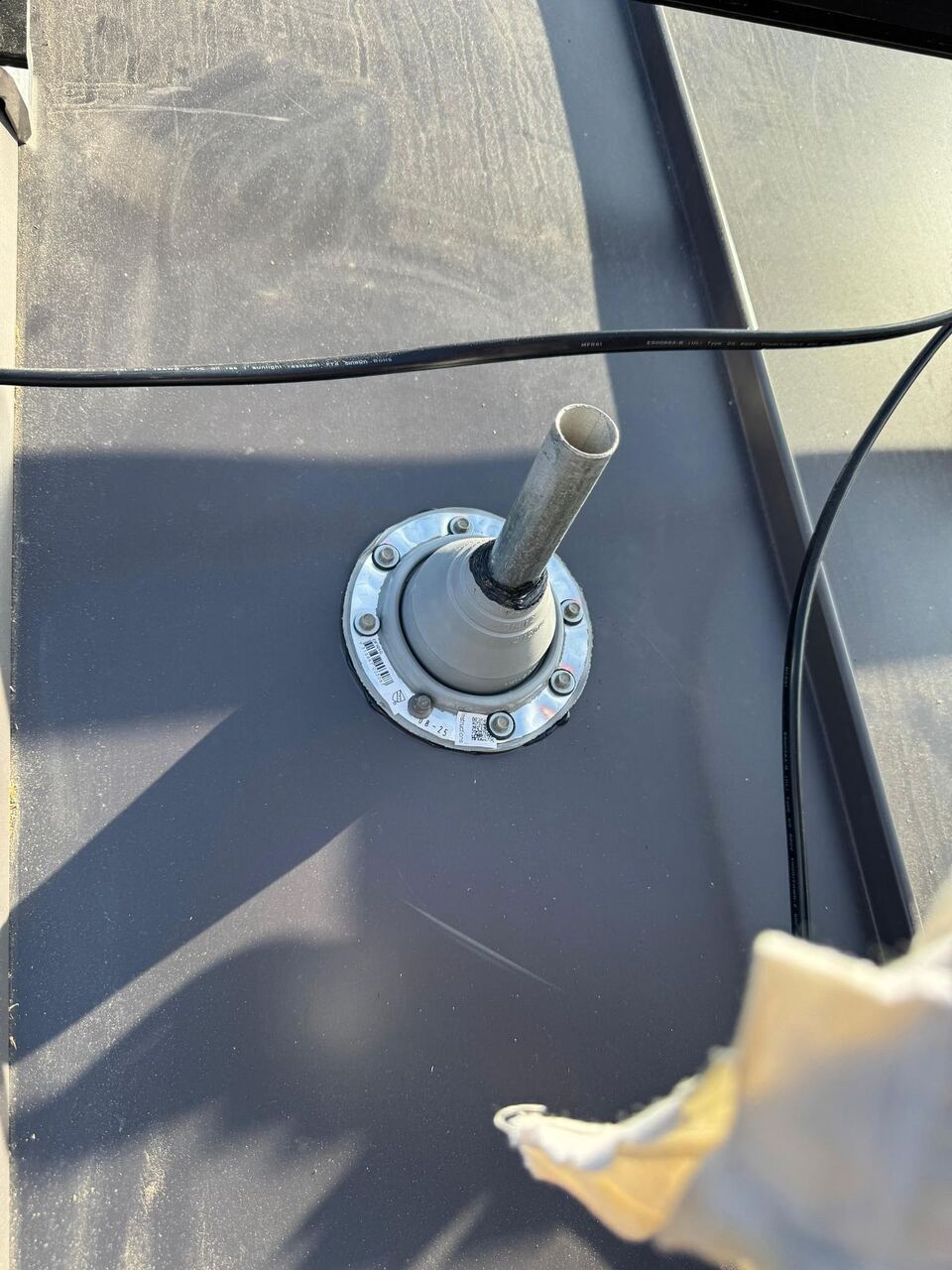 Gasketed pipe boot sealed to standing seam metal roof panel
